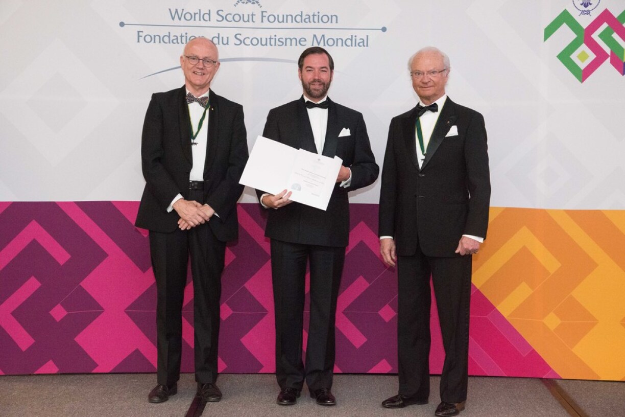 Lors de son adminssion comme membre de la Fondation mondiale du Scoutisme, S.A.R. le Grand-Duc héritier est entouré, de g. à dr., par M. Lars Kolind, Officer, Chairman de la « World Scout Foundation » et S.M. Carl XVI Gustaf, roi de Suède et Honorary Chairman de la « World Scout Foundation »