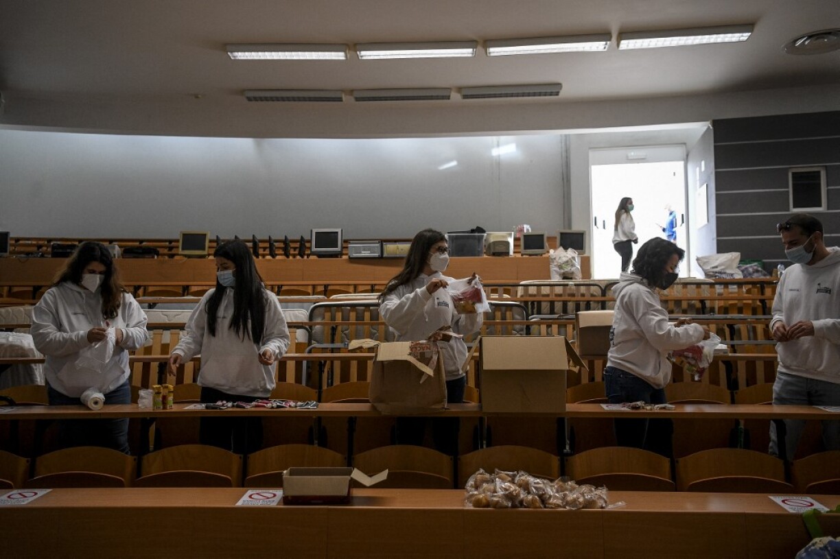 Des volontaires en train de préparer des repas pour les soignants dans un amphithéâtre de l'université de Lisbonne.
