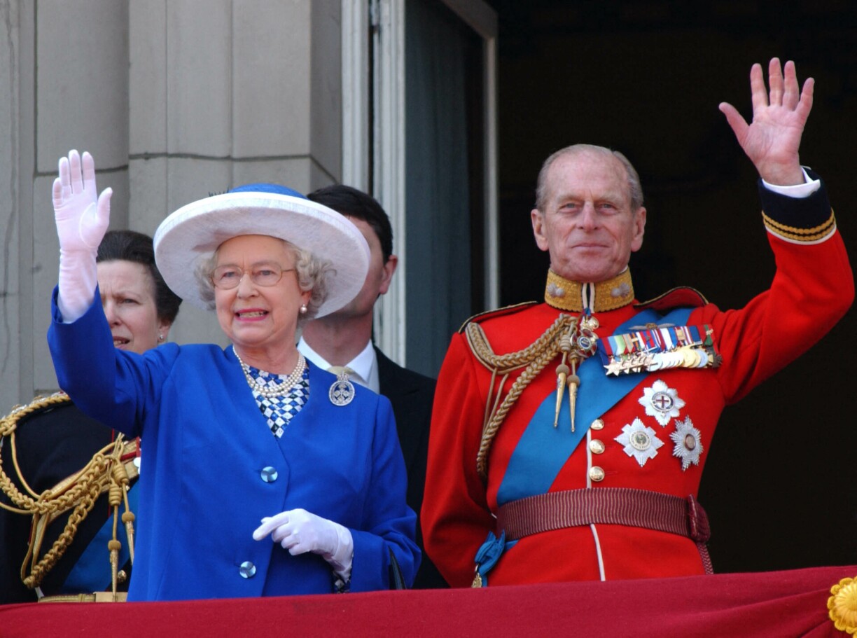 June 14, 2003 Britain's Queen Elizabeth II (L) and Britain's Prince Philip, Duke of Edinburgh (R) wave from the balcony of Buckingham Palace in London, during a flypast for the trooping of the colour.