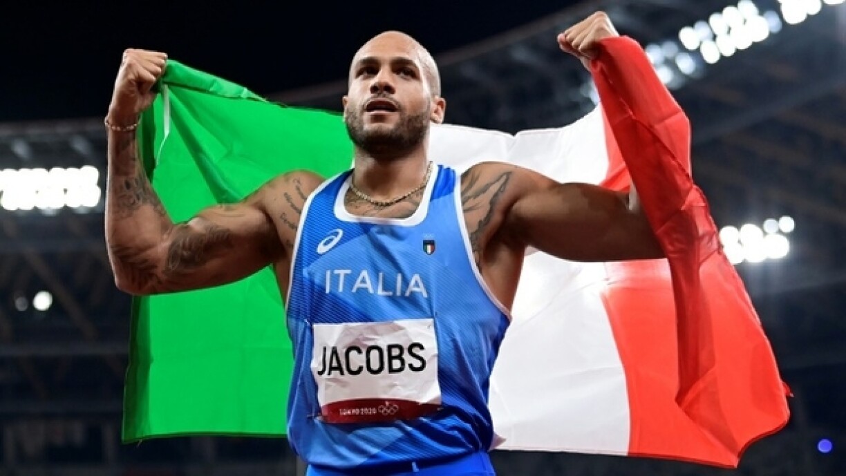 L'Italien Marcell Jacobs célèbre avec le drapeau de l'Italie son triomphe en finale du 100 m masculin lors des Jeux olympiques de Tokyo, au stade olympique de Tokyo, le 1er août 2021.