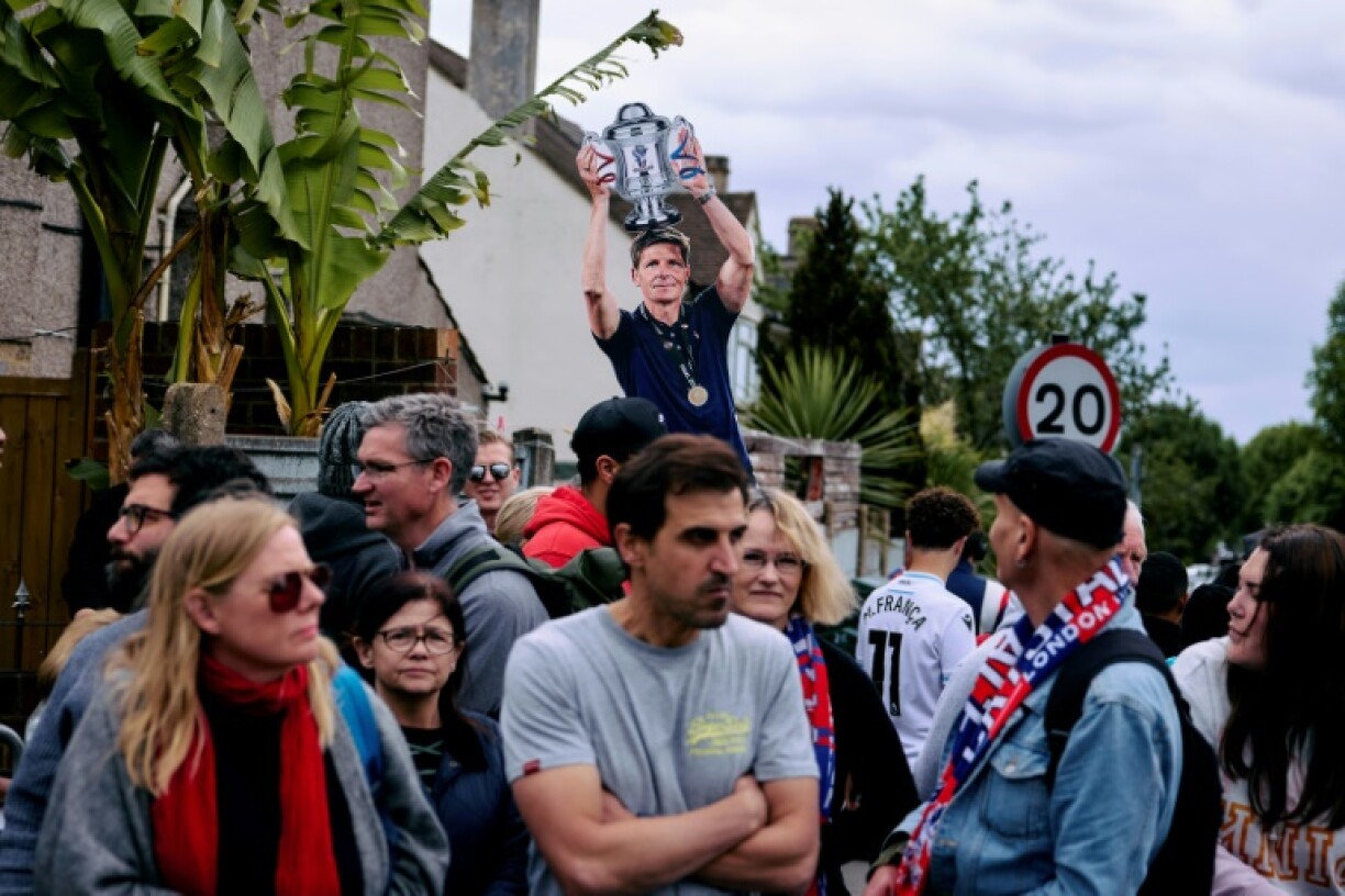 Crystal Palace supporters near Selhurst Park celebrate around a cardboard depicting manager Oliver Glasner as they wait for the arrival of an open-top bus parade in honour of the club's FA Cup final win