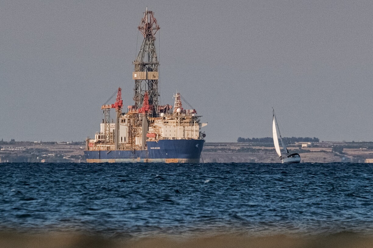 A sailing vessel passing near the drill ship