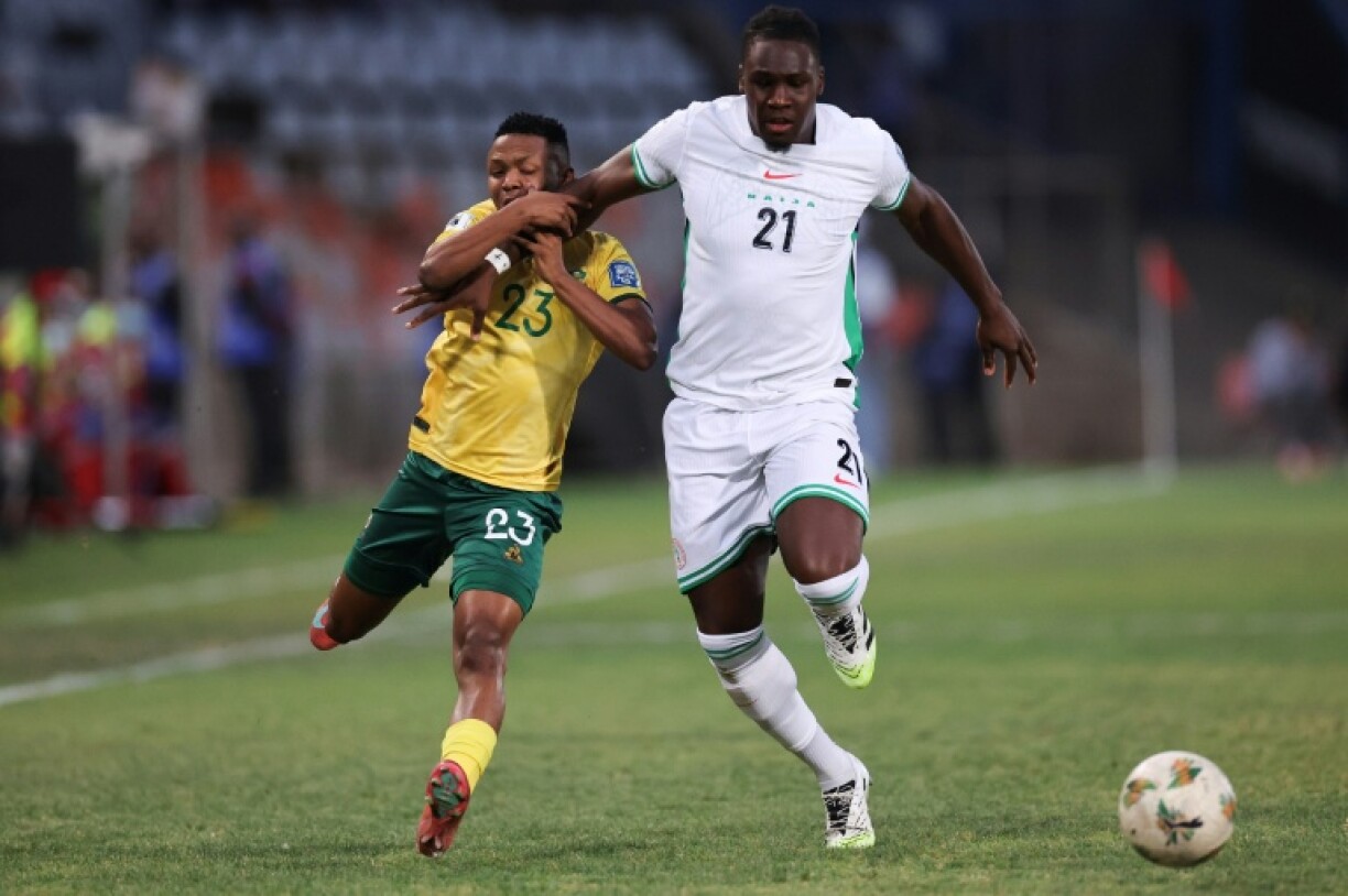 Nigeria's scorer Calvin Bassey (L) holding off South Africa's Mohau Nkota of South Africa in a drawn World Cup qualifier in Bloemfontein