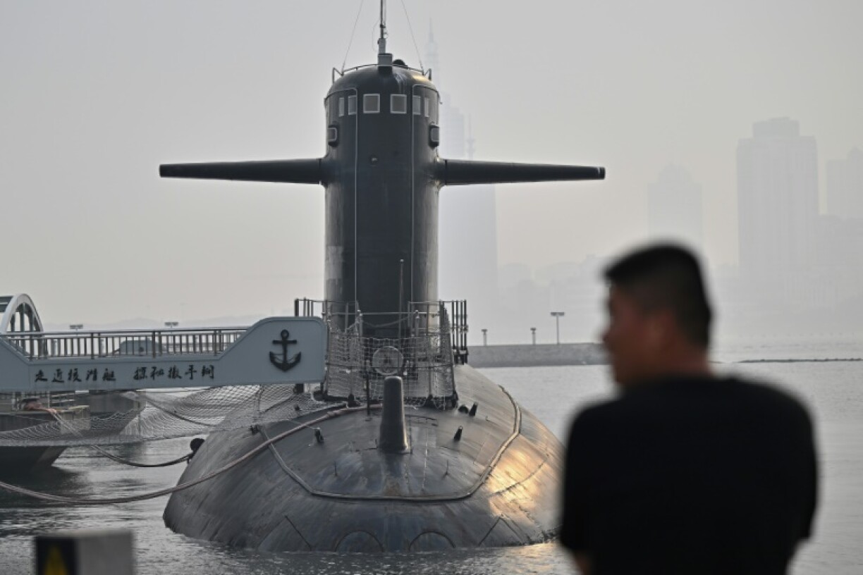 A man looks at a submarine during a media tour by the PLA Naval Museum, organized by the Chinese People's Liberation Army Navy