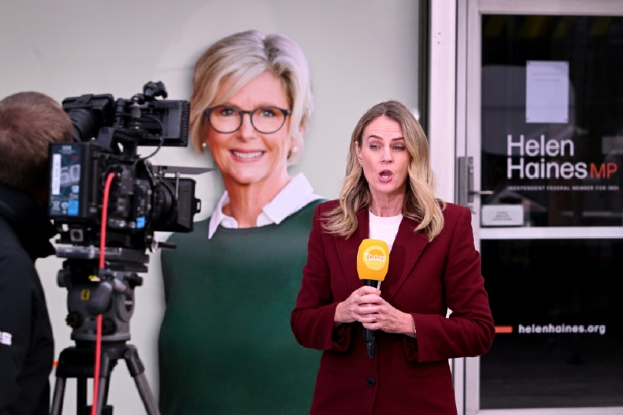 A TV crew works in front of a portrait of Australian politician Helen Haines (C) outside her office in the northern regional city of Wangaratta, about 250 kilometres north-east of Melbourne on October 20, 2026