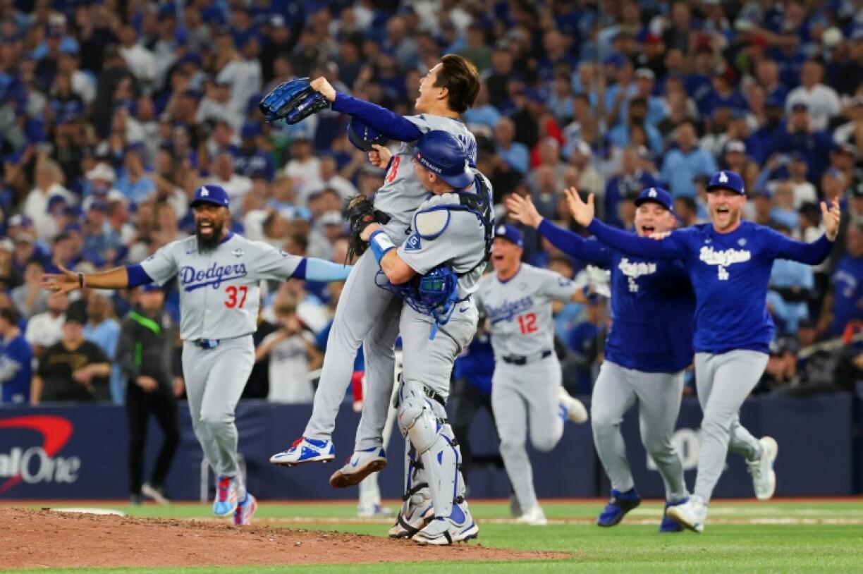 Yoshinobu Yamamoto is hoisted aloft by Los Angeles Dodgers team-mate Will Smith after the World Series win over Toronto