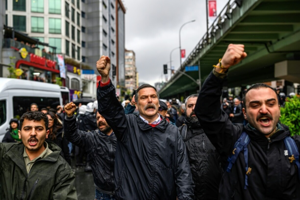 le président du Parti des travailleurs de Turquie, Erkan Bas (c) lève le poing lors lors d'un rassemblement à Istanbul, à l'occasion de la Journée internationale des travailleurs, le 1er mai 2026 en Turquie