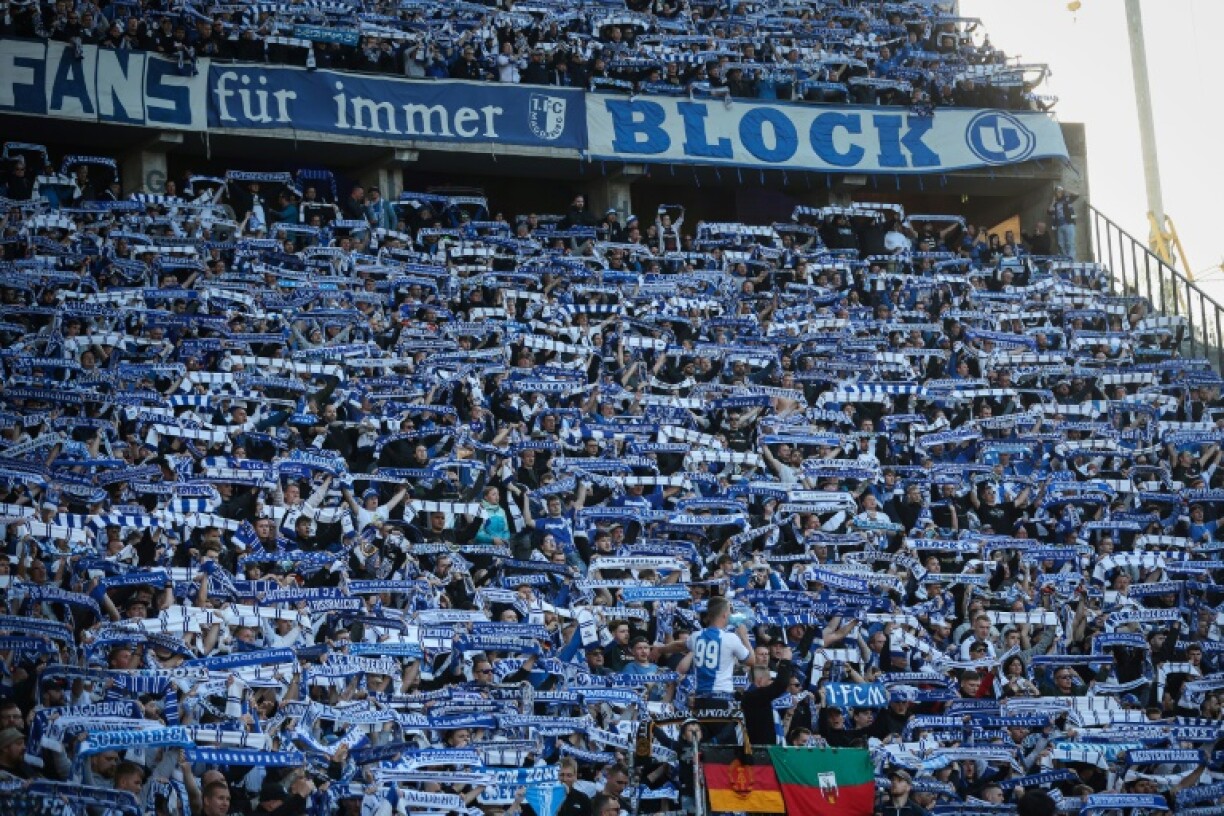 Supporters of German second-division side Magdeburg hold up fan scarves in a match against Hertha Berlin in April