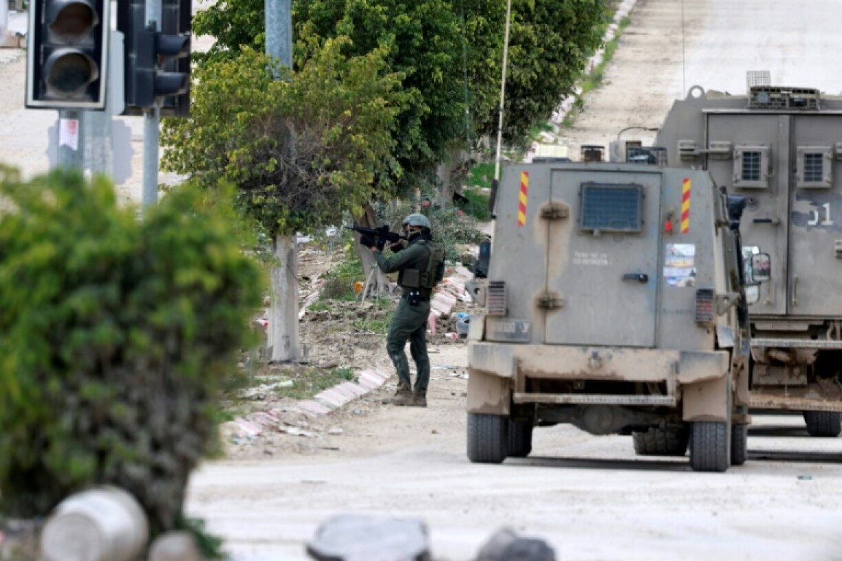 An Israeli soldier points his weapon near the entrance of the occupied West Bank refugee camp of Tulkarem on Friday