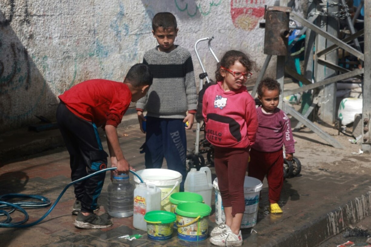 Des enfants palestiniens déplacés par la guerre vont chercher de l'eau à Rafah, le 30 mars 2024