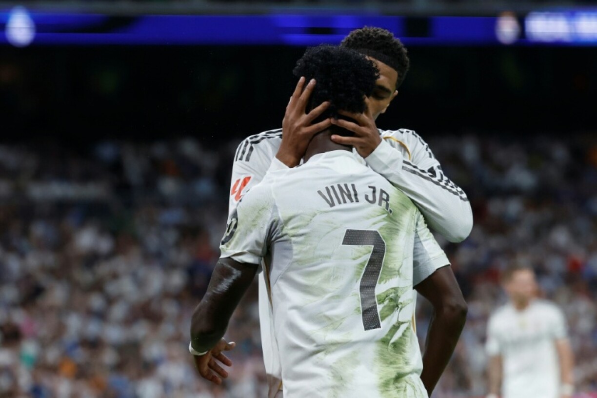 Jude Bellingham embrasse Vinicius Junior (de dos) lors d'un match du championnat espagnol entre le Real Madrid et Villarreal le 4 octobre 2025 au stade Santiago-Bernabeu