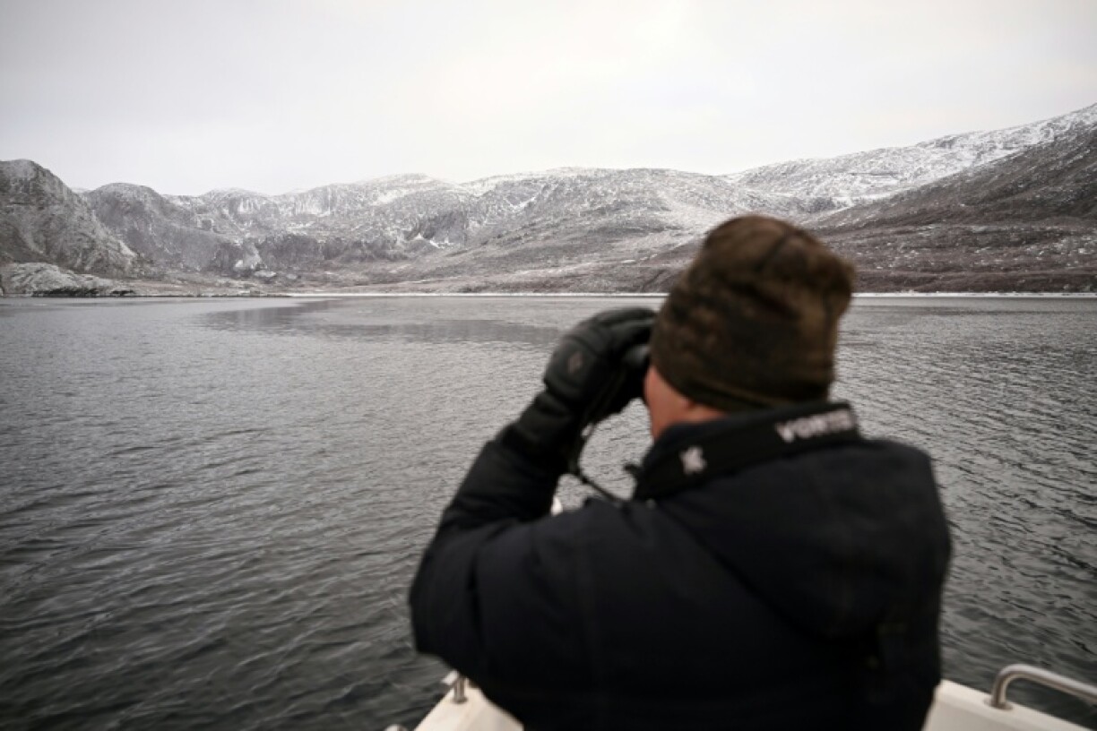 Un chasseur à bord de son bateau, recherche des phoques dans un fjord près de Sisimiut, au Groenland, le 1er février 2026