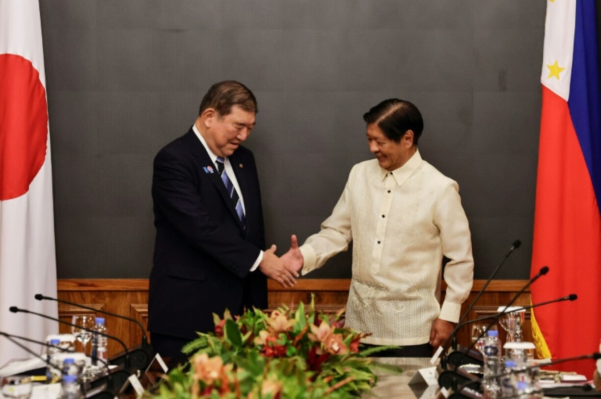 Japanese Prime Minister Shigeru Ishiba (L) and Philippine President Ferdinand Marcos shake hands before the start of their bilateral meeting on Tuesday