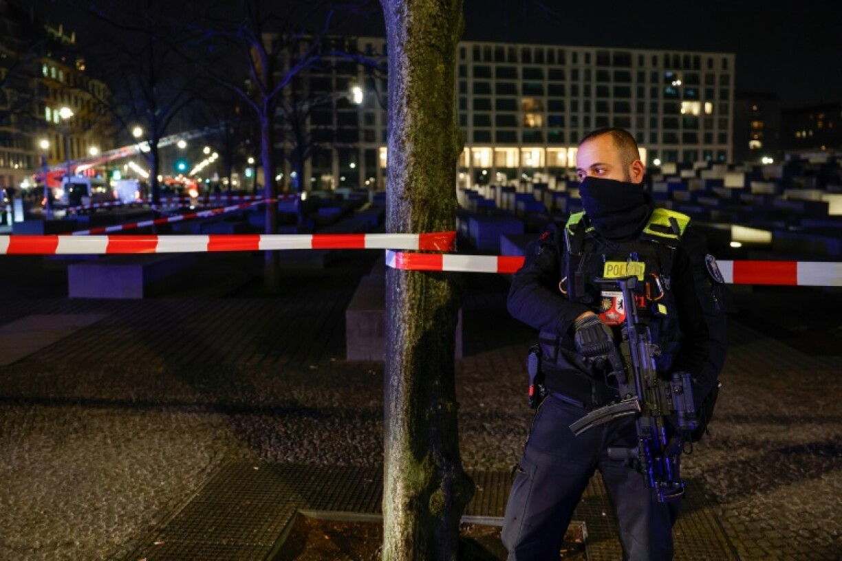 An armed police officer at the cordoned off crime scene
