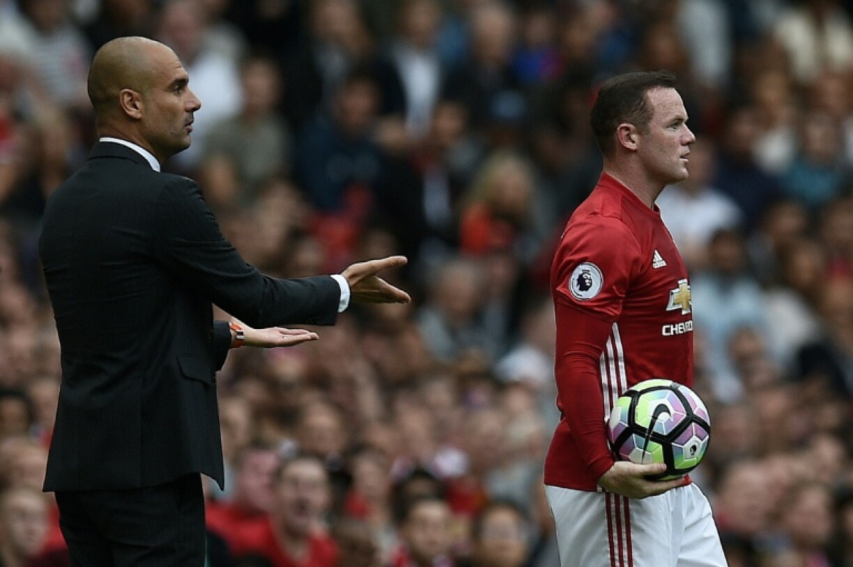 Former Manchester United striker Wayne Rooney (R) stands next to ex-Manchester City boss Pep Guardiola