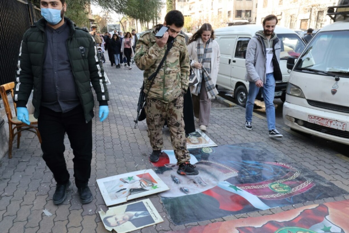 Syrians step on portraits of toppled president Bashar al-Assad in Damascus