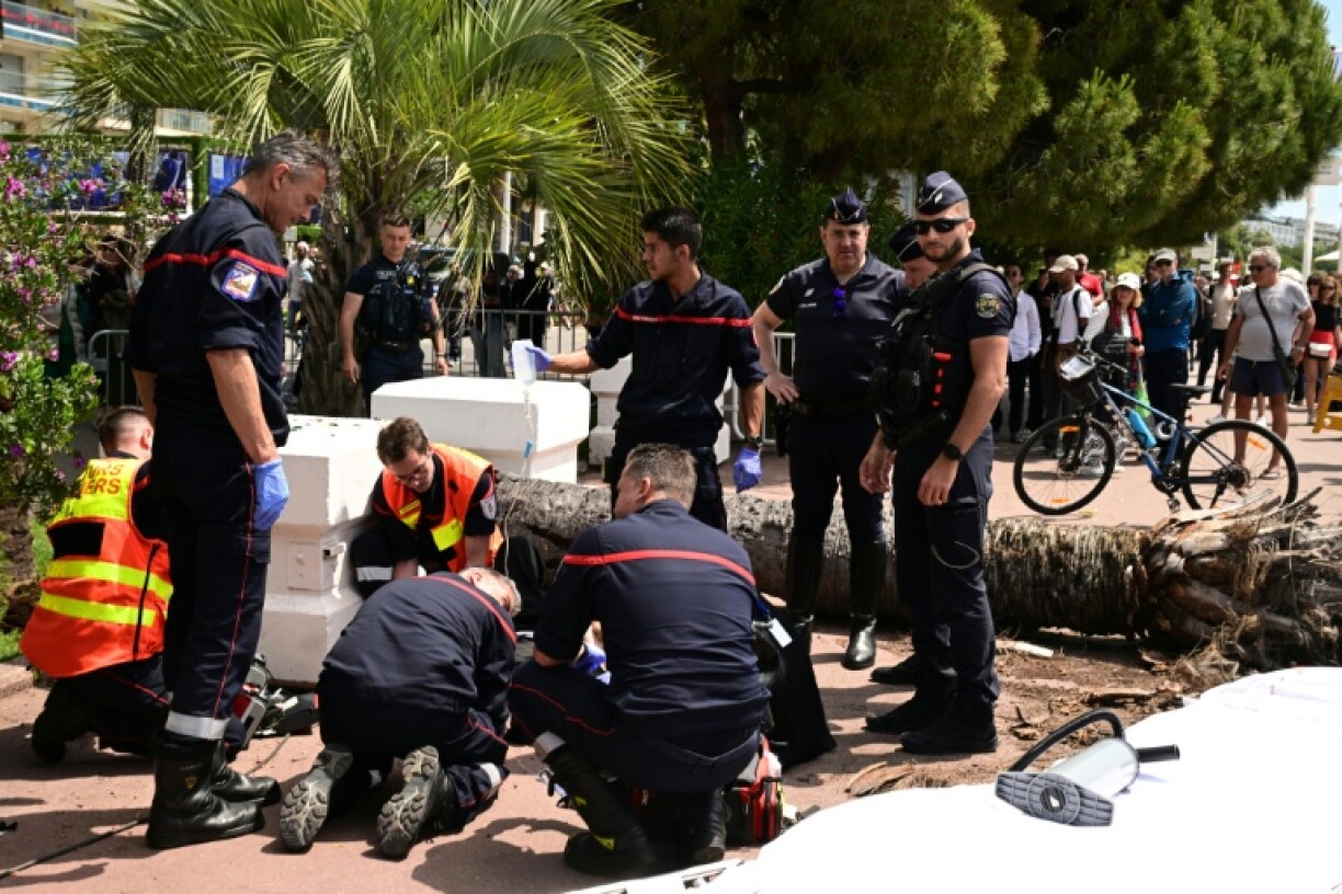 Firemen treated a badly injured man next to the fallen palm tree at Cannes