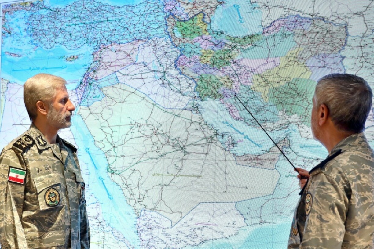 A handout picture provided by the Iranian Army media office shows army chief Amir Hatami (L) at his war command room
