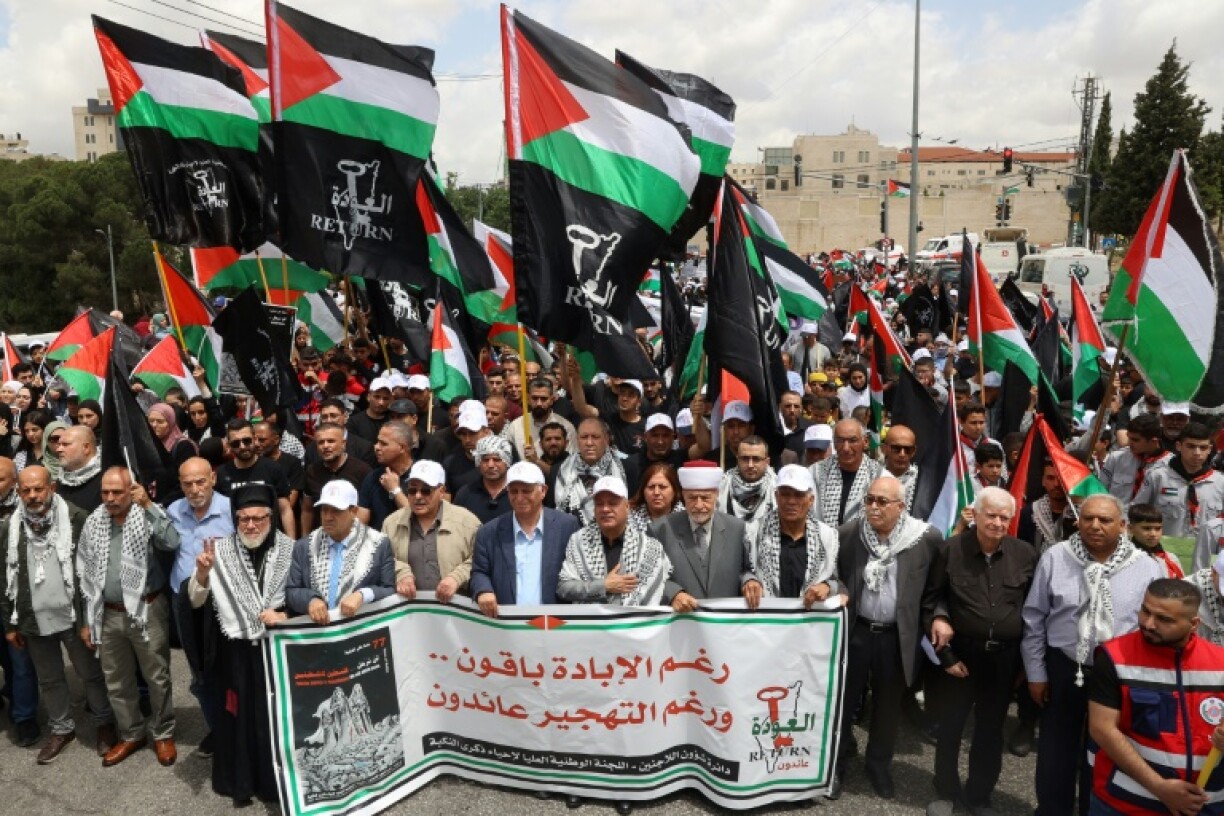 Palestinians wave national flags as they commemorate the 77th anniversary of the