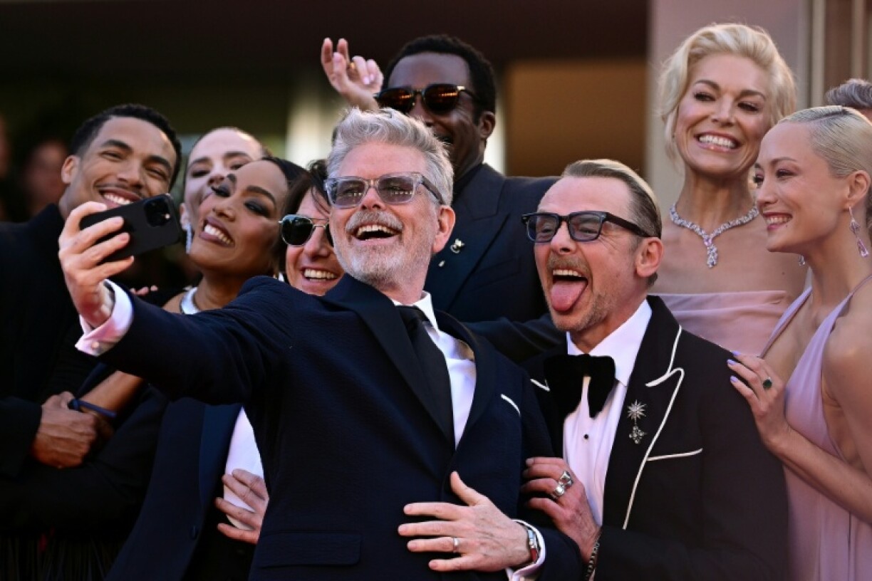 Director Christopher McQuarrie (C) takes a selfie with the 'Mission: Impossible' cast on the red carpet at Cannes