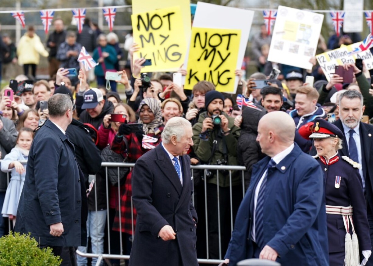 Le roi Charles III (c) accueilli par une poignée de militants anti-monarchie, lors d'un déplacement à Milton Keynes, le 16 février 2023 au nord de Londres