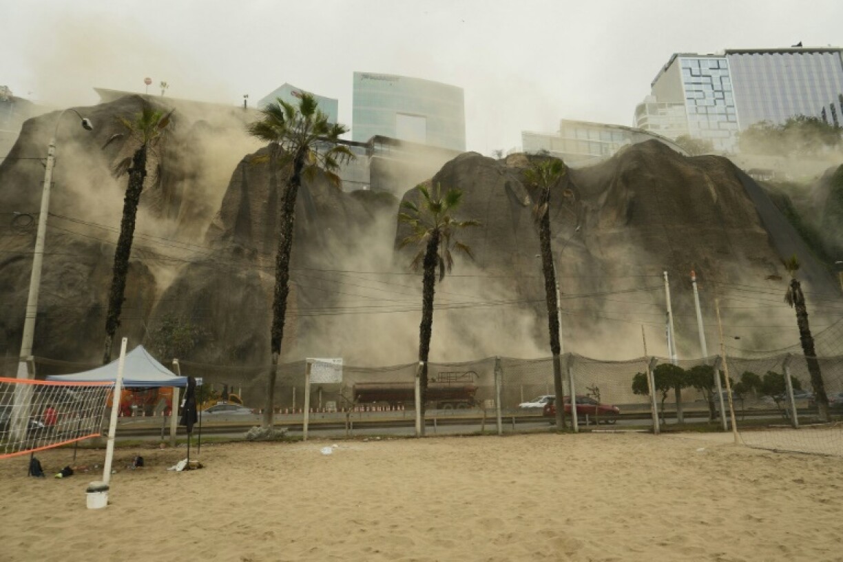 Dust billowed out of a landslide in the capital Lima, where one person was killed when a wall fell on his vehicle