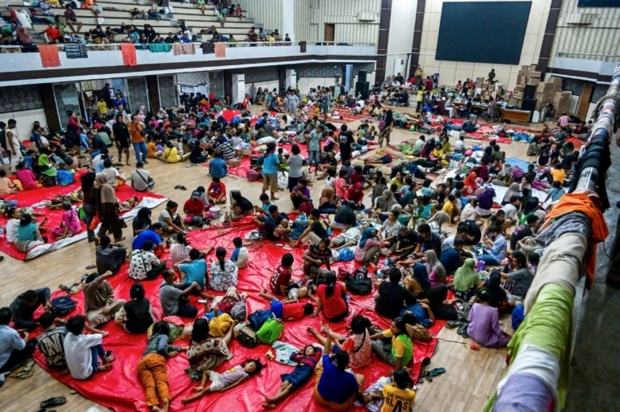 Displaced residents rest in a shelter following flash floods and landslides in Pandan in Central Tapanuli, Indonesia's North Sumatra province on November 30