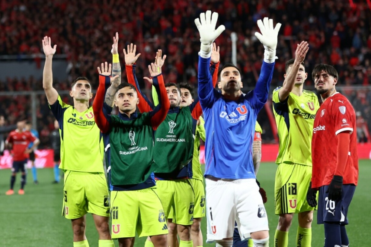 Players of Universidad de Chile call for calm among the fans in the stands during the interruption