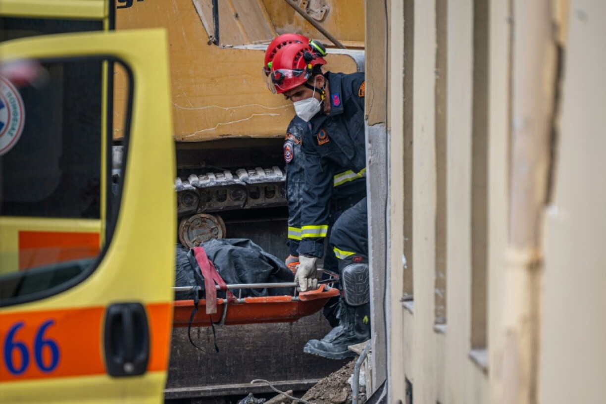 Des secouristes transportent le corps d'une personne retrouvée sous les décombres après l'effondrement d'un immeuble à Athènes, le 26 septembre 2026