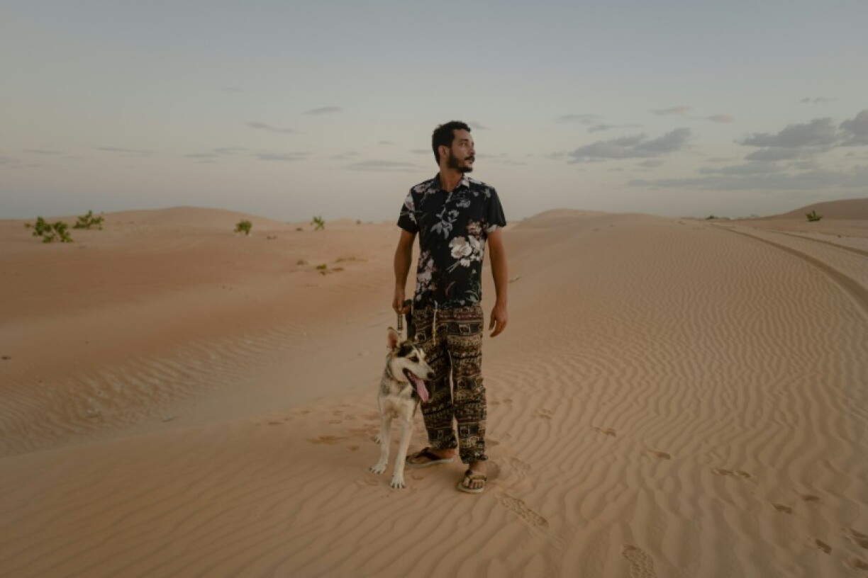 Ahmed Maham et son chien husky sibérien Kayo dans les dunes de Nouakchott, en Mauritanie, le 9 octobre 2024