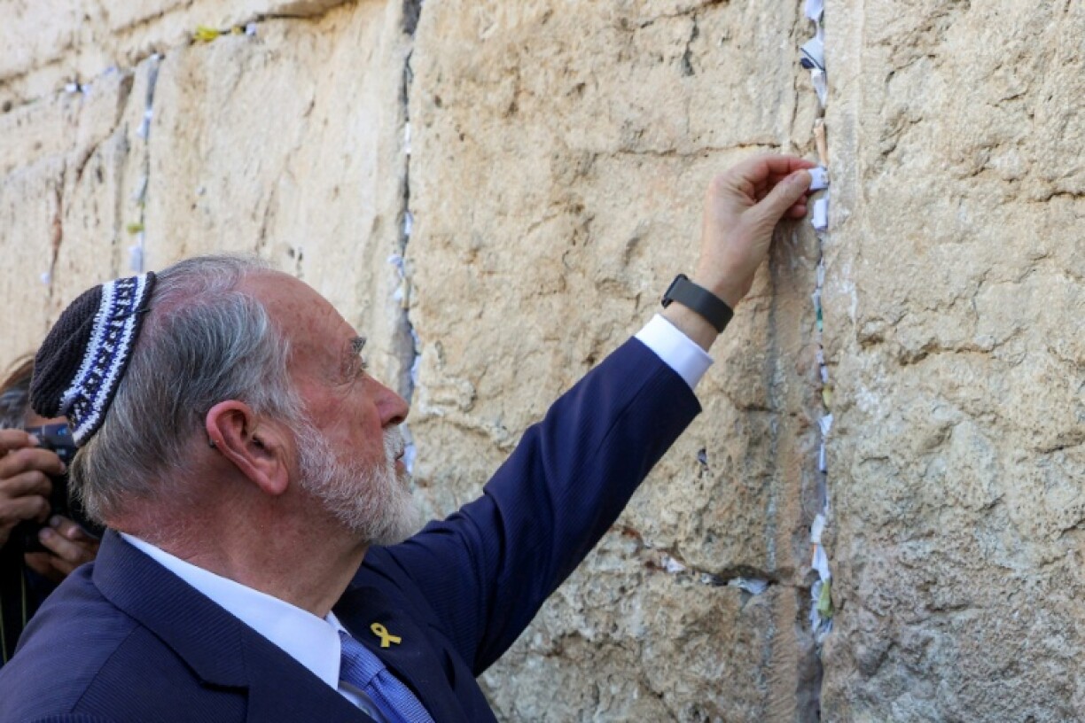 United States ambassador to Israel Mike Huckabee places a note given to him by US President Donald Trump in the cracks of the Western Wall, in Jerusalem's Old City