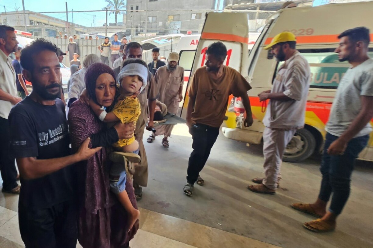 Palestinian carry their child wounded in an Israeli strike on a camp for displaced people near Khan Yunis, as they arrive at the Nasser Hospital in the southern Gaza Strip city on July 8, 2025