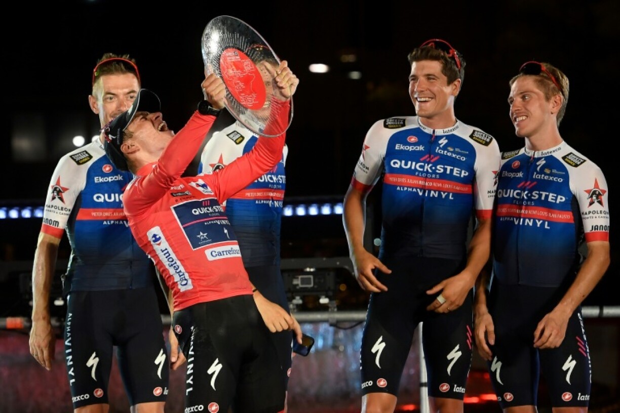 Remco Evenepoel, avec son maillot rouge distinctif, célèbre sa victoire finale dans la Vuelta le 11 septembre 2022 à Madrid au milieu de ses équipiers. Le jeune Belge remporte à 22 ans son premier grand Tour, le premier aussi conquis par un coureur de la Quick-Step, plutôt taillée pour les classiques