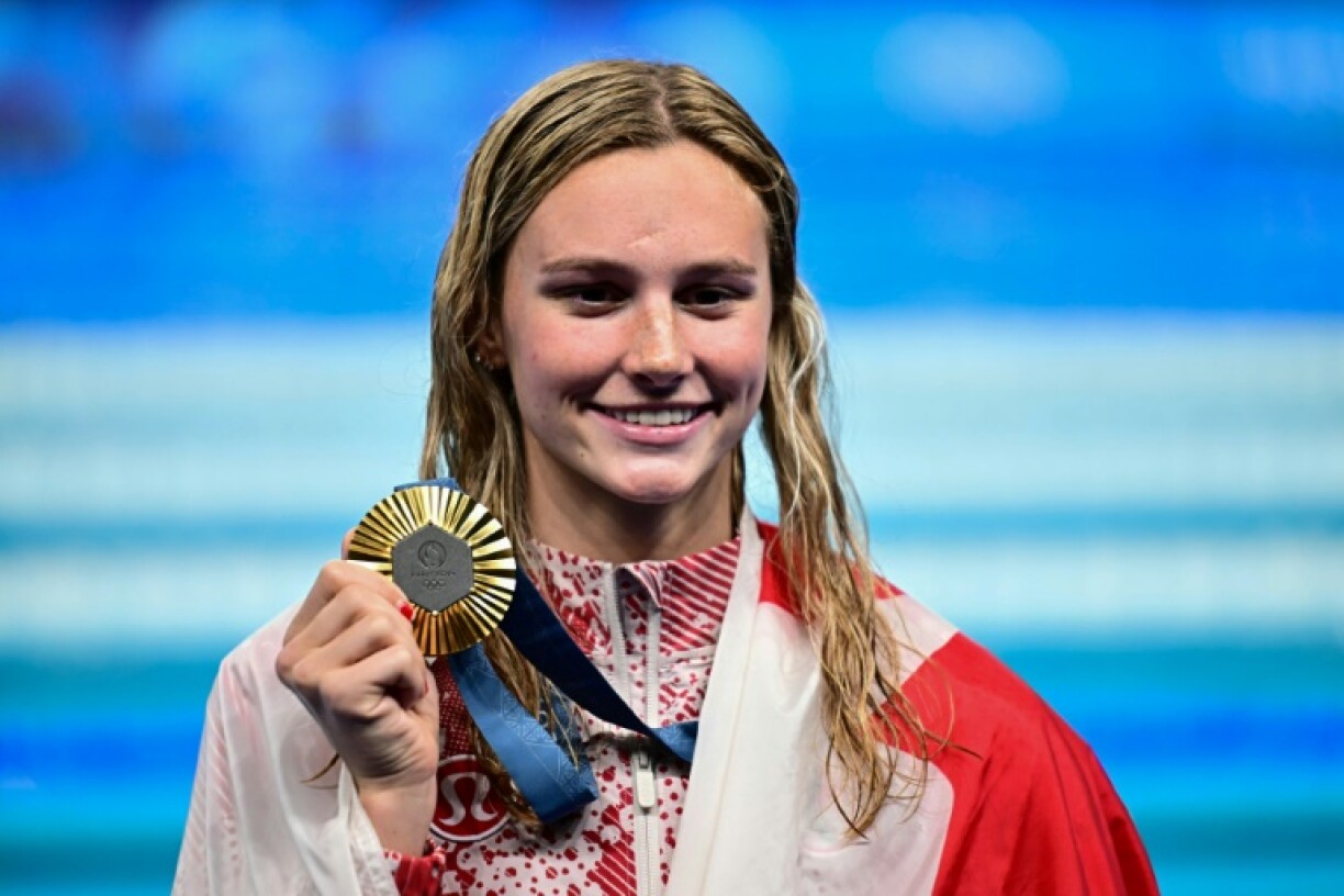 Canadian Summer McIntosh celebrates on the podium after winning the 200m individual medley at the Paris Olympics