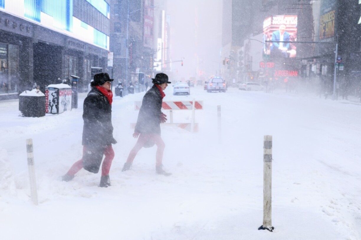 Des passants sur la 6e avenue en pleine tempête de neige à New York le 25 janvier 2026