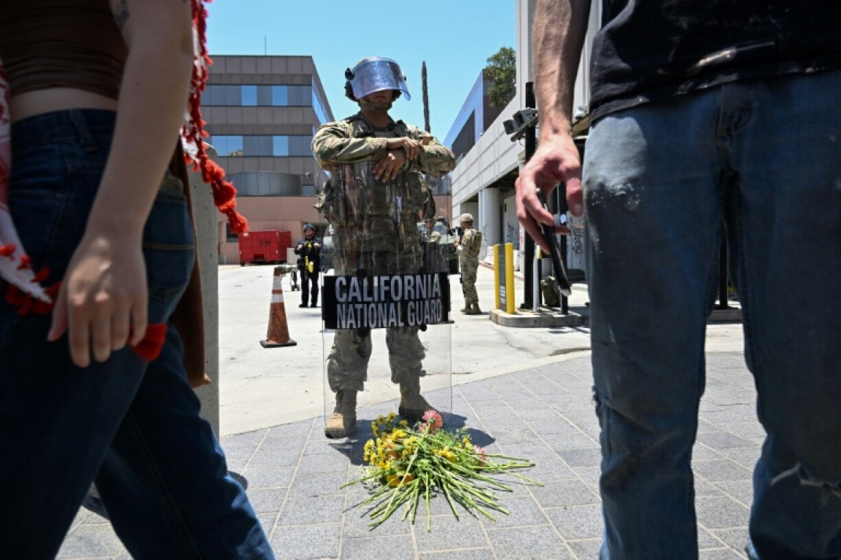 Members of the clergy and other protesters placed flowers at the feet of a California National Guardsman statione outside federal buildings in Los Angeles