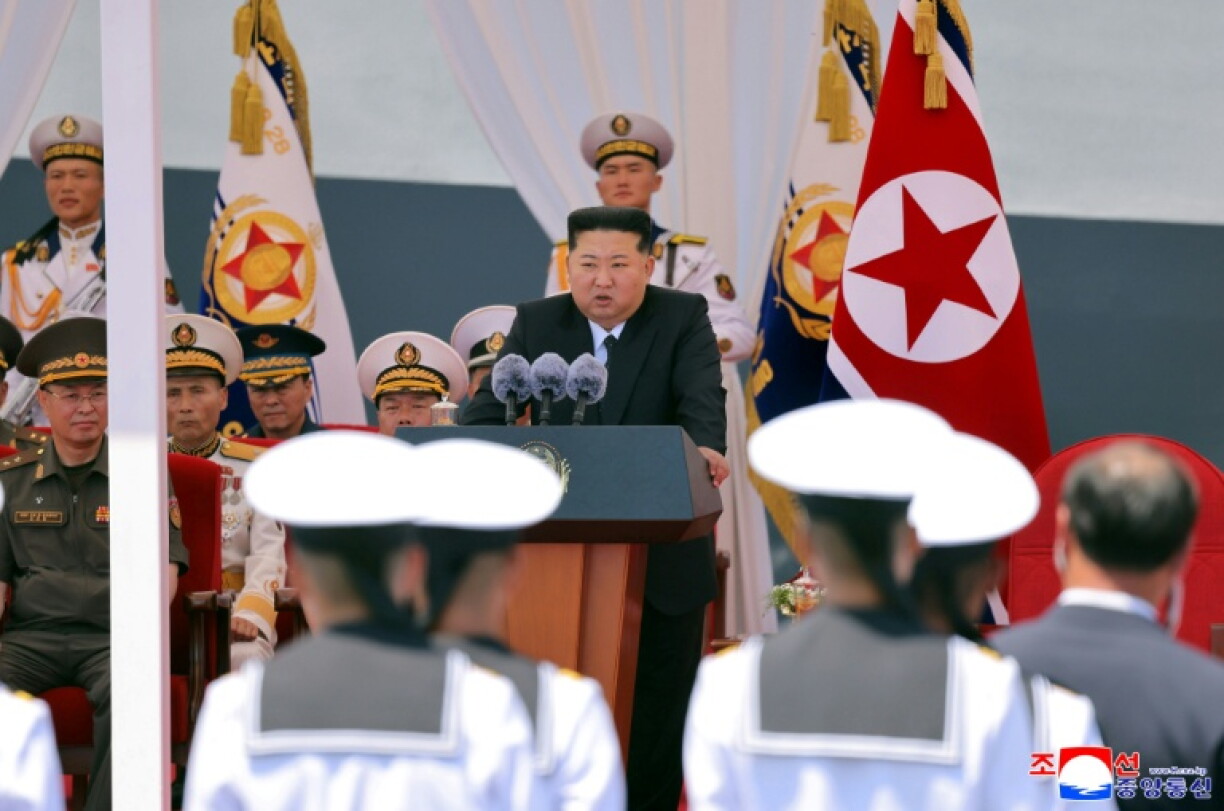 Cette photo, prise le 23 juin 2026 et diffusée le lendemain par l'agence de presse officielle nord-coréenne KCNA, montre le dirigeant nord-coréen Kim Jong Un (au centre) prononçant un discours, au port de Nampo, en Corée du Nord