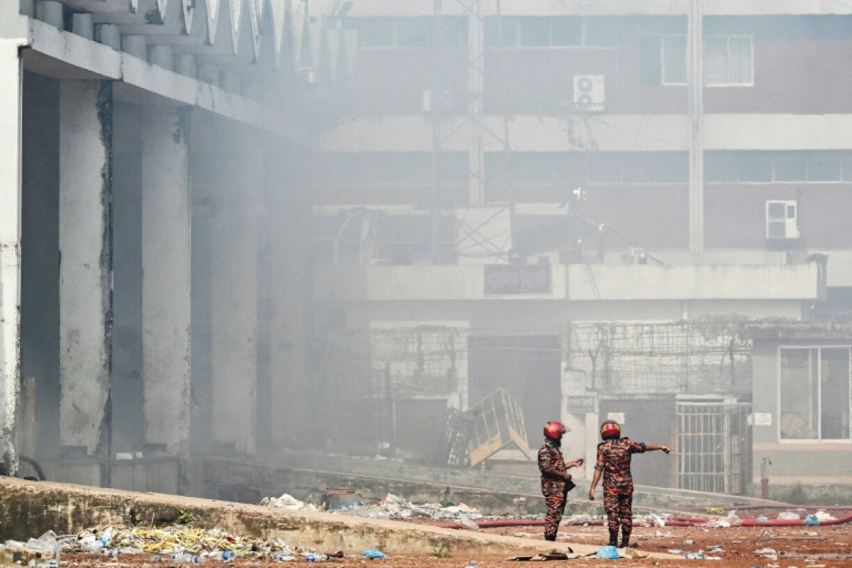 Firefighters inspect the fire-damaged cargo terminal of Hazrat Shahjalal International Airport in Dhaka on October 19, 2025, a day after the blaze