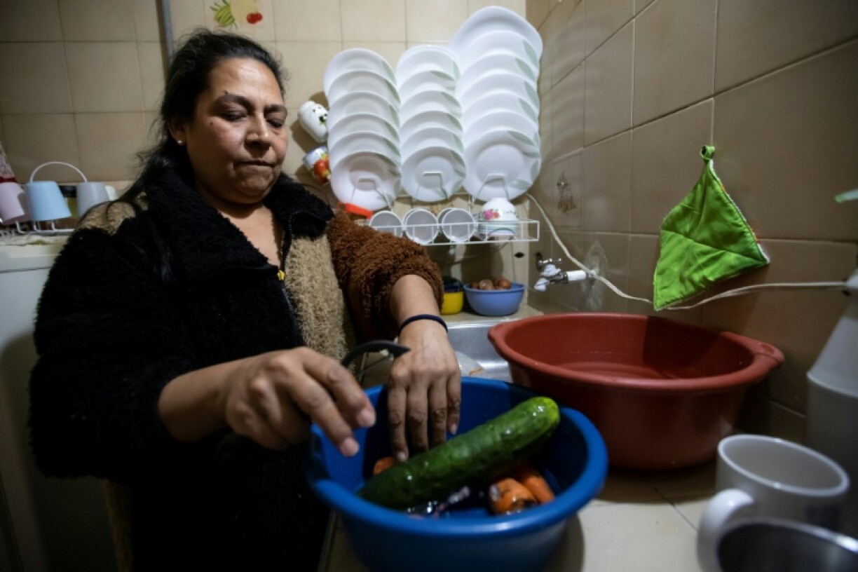Briceida Torres washes food with water she stores in containers a few days before the end of the first year of water rationing at her house in Bogota in April 2025
