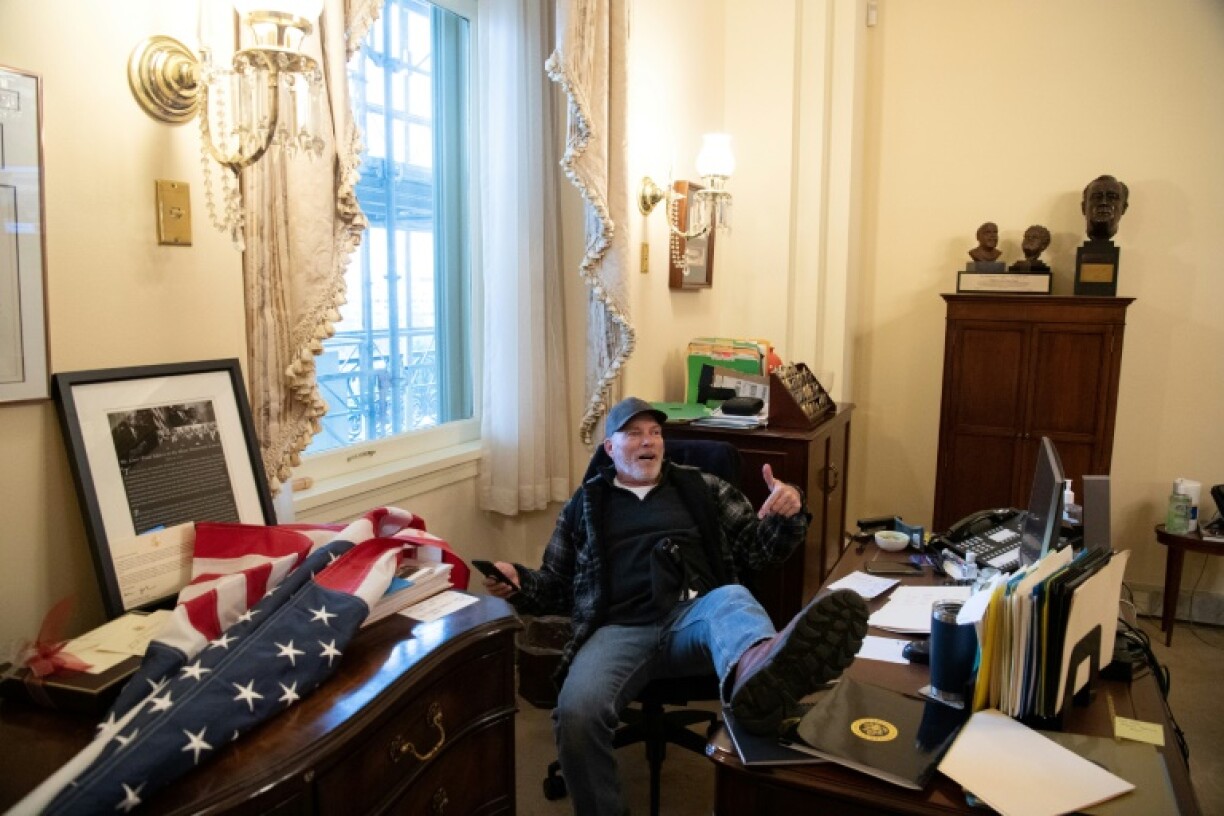 Un manifestant force le bureau de la présidente de la Chambre, Nancy Pelosi, et se fait immortaliser les pieds sur sa table de travail
