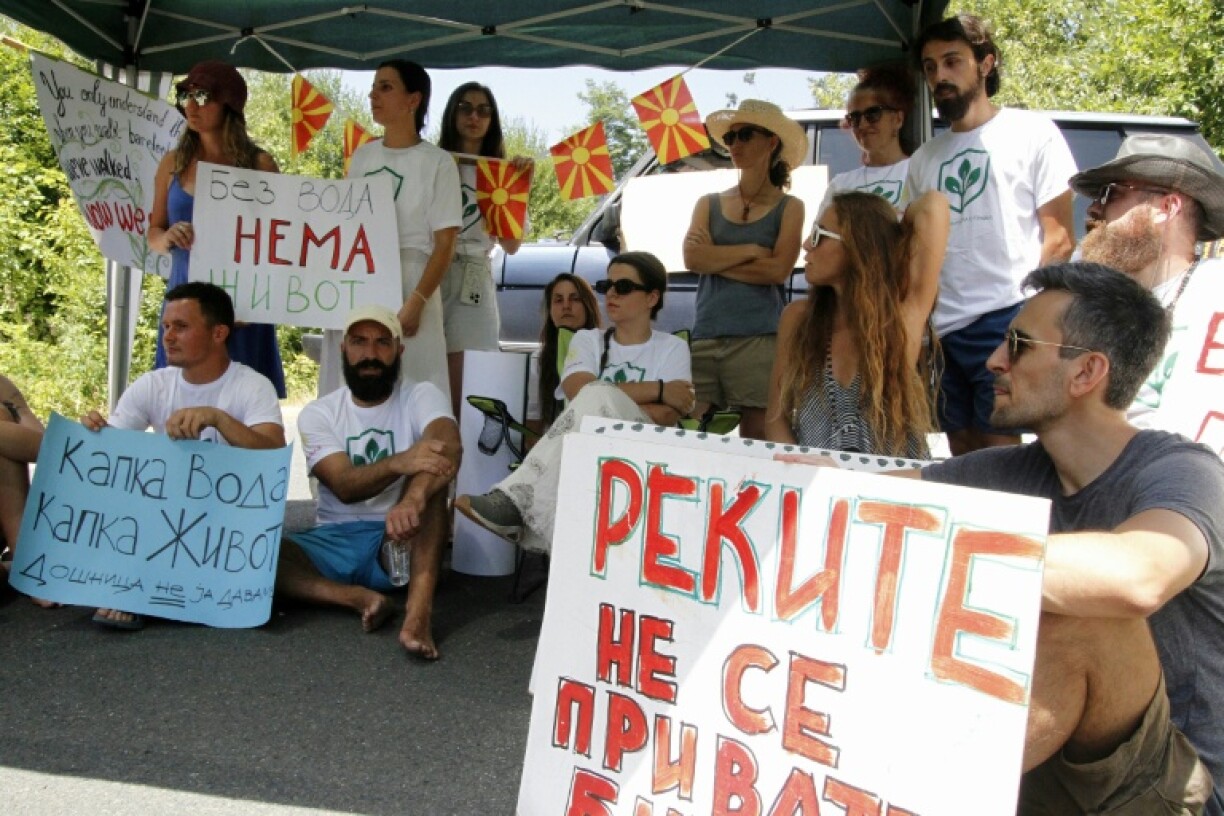 Environmental activist hold a banner reading