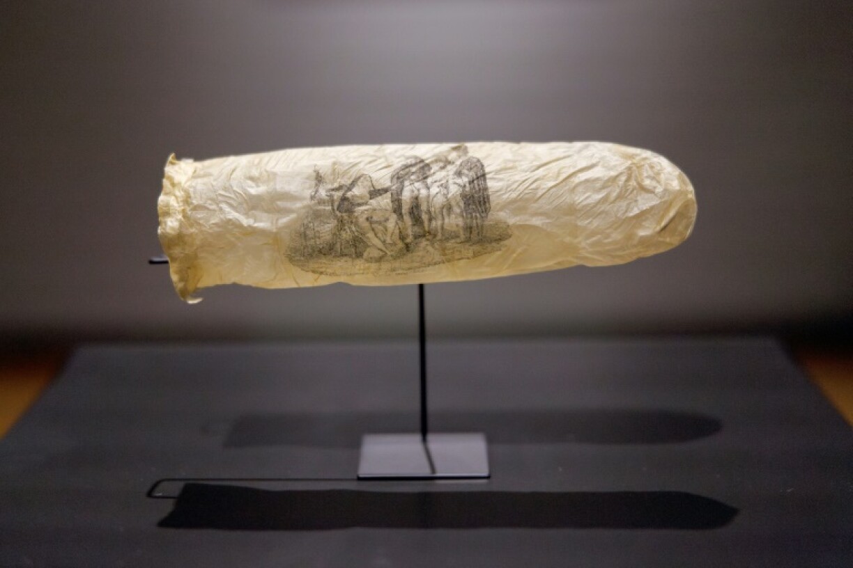 A rare 19th-century condom bearing an erotic print, possibly made from sheep intestine, is displayed at the Rijksmuseum in Amsterdam. Part of a new exhibition exploring sexuality and prostitution in the 1800s, the sheath features a nun and three clergymen in provocative poses.