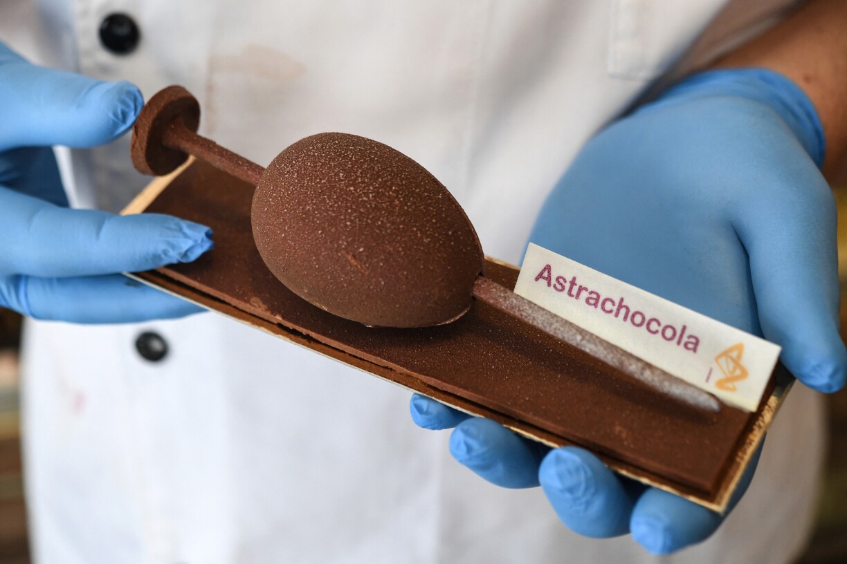 Chocolatier Jean-François Pre holds his creation of a syringe made with black chocolate dubbed
