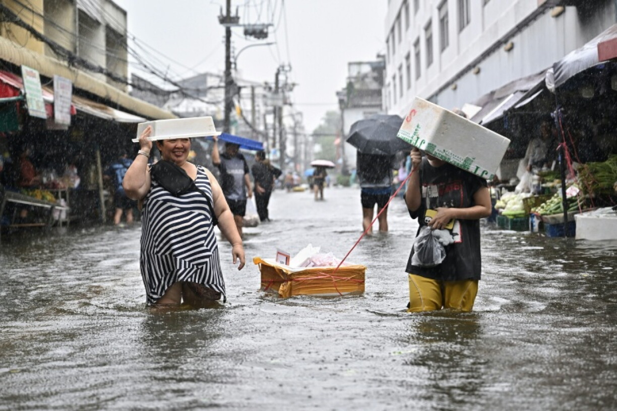 Residents navigate floodwaters and heavy rain in Bang Kapi district in Bangkok