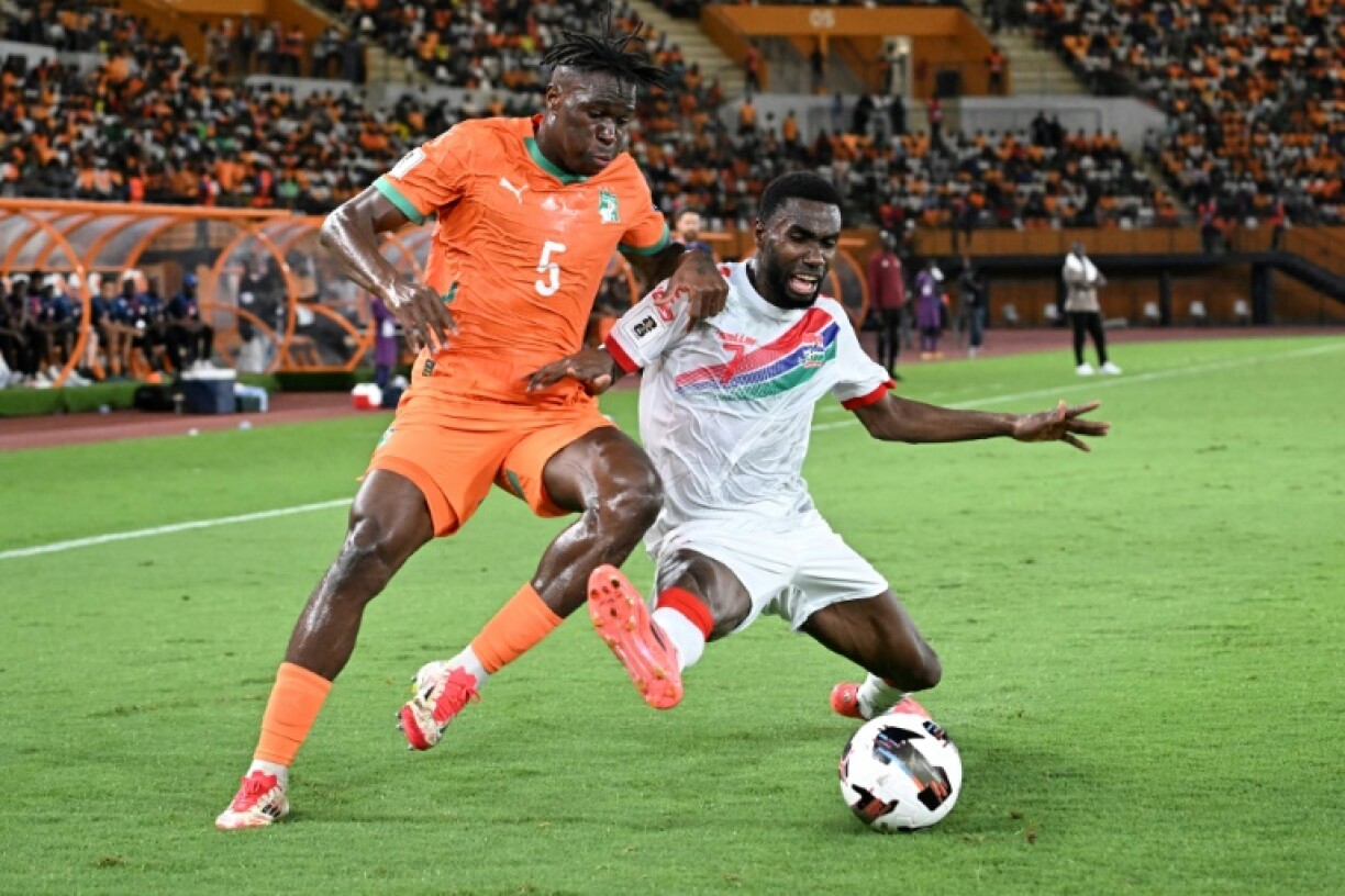 Wilfried Singo of Ivory Coast (L) and Alieu Fadera of Gambia fight for the ball in a 2026 World Cup qualifier in Abidjan.