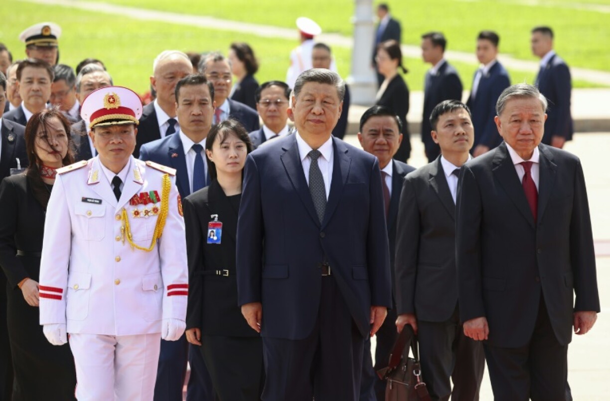 Chinese President Xi Jinping (C) walks with Vietnam's Communist Party General Secretary To Lam (R) at the Ho Chi Minh Mausoleum in Hanoi