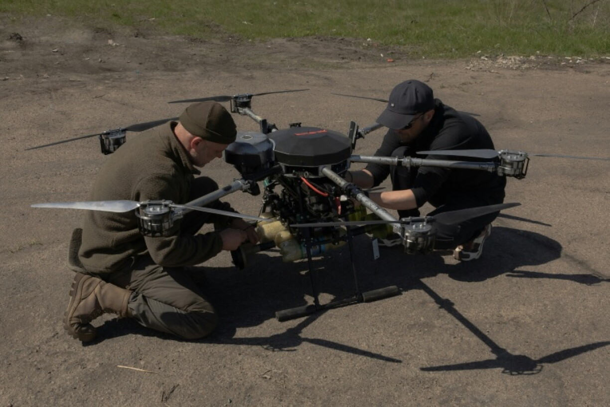 Des militaires ukrainiens de la 67e brigade mécanisée fixent des engins explosifs sur un drone bombardier lourd lors d'un exercice d'entraînement dans un lieu tenu secret de la région de Dnipropetrovsk, le 17 avril 2026