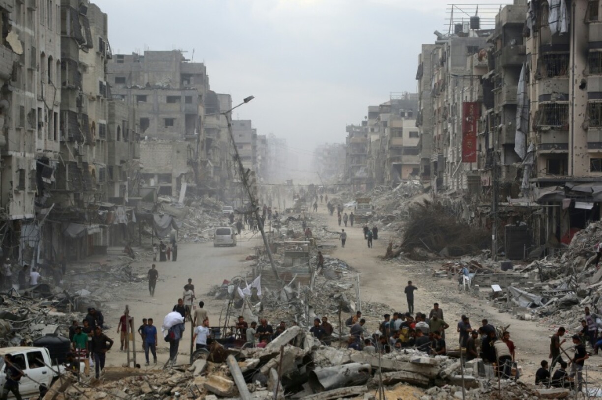 Des Palestiniens au milieu de bâtiments détruits dans la ville de Gaza, le 12 octobre 2025