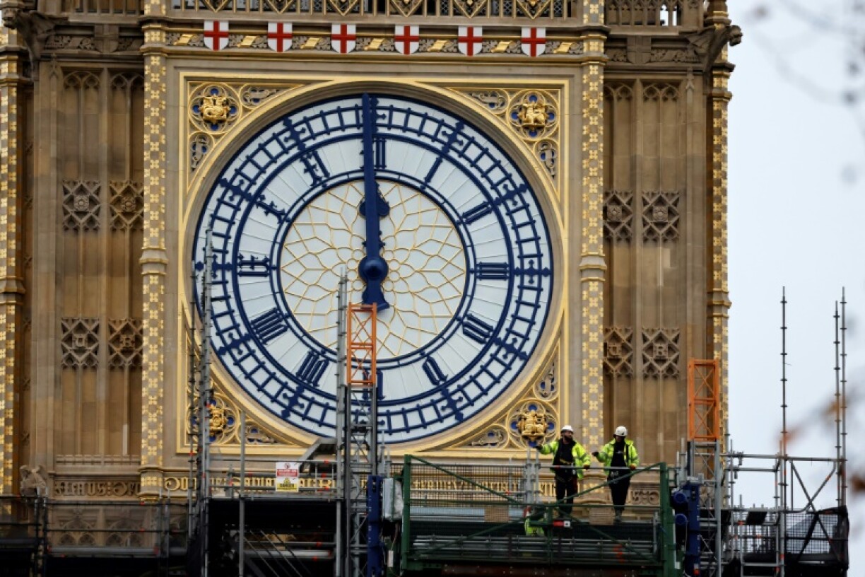 Des ouvriers devant le cadran ouest de la tour Elizabeth, connue sous le nom de sa célèbre cloche Big Ben, au palais de Westminster à Londres, le 20 décembre 2021