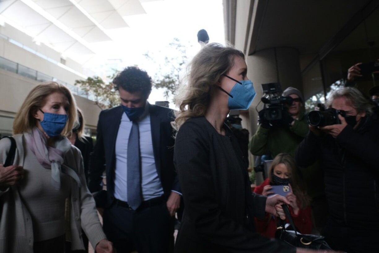 Elizabeth Holmes (d) arrive au tribunal de San José, en Californie, accompagnée de son compagnon Billy Evans (c) et de sa mère, le 3 janvier 2022